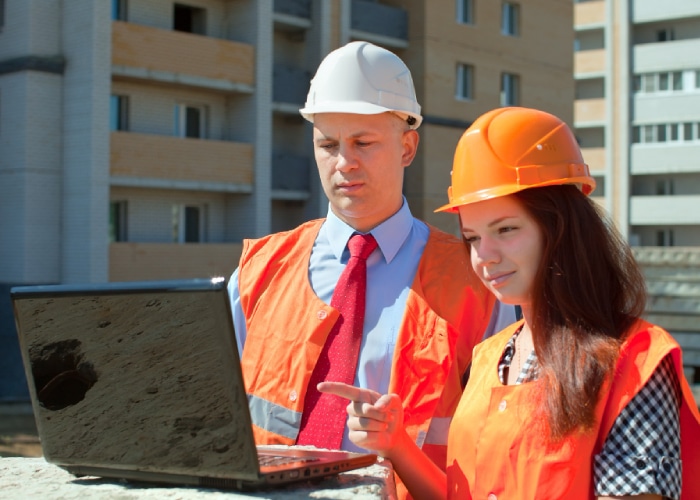 duo de professionnels regardant un ordinateur sur un chantier